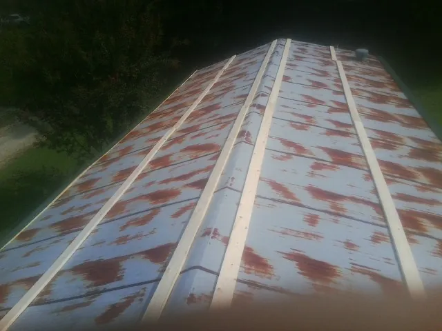 Rusted metal roof panels with new wood purlins before replacement — Storm Damage Roof Repair in Conley by Roofing Brothers
