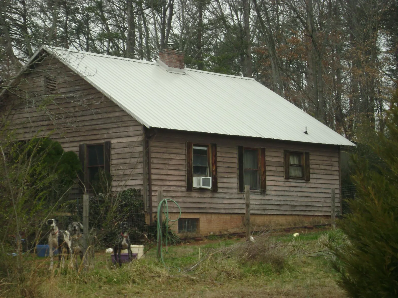 White metal roof on an old wood sided farmhouse, from a Metal Roof Installation job in Conley